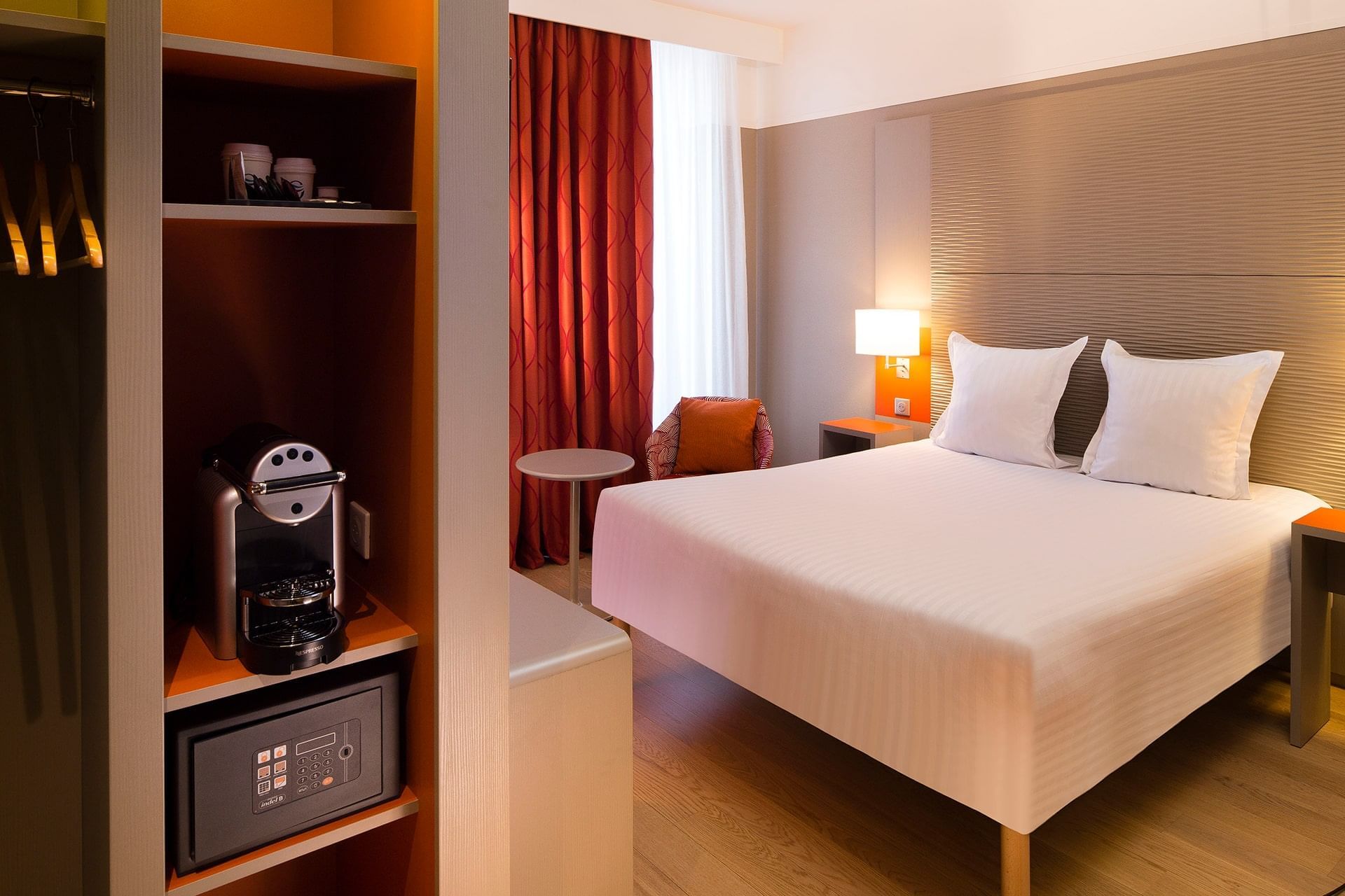 Lit queen-size avec coffre-fort dans une chambre Supérieure à l'Oceania Le Jura Dijon