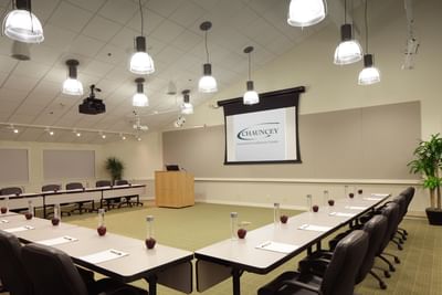Modern conference room with U-shaped table setup, and projection screen at Aramark Chauncey Conference Center