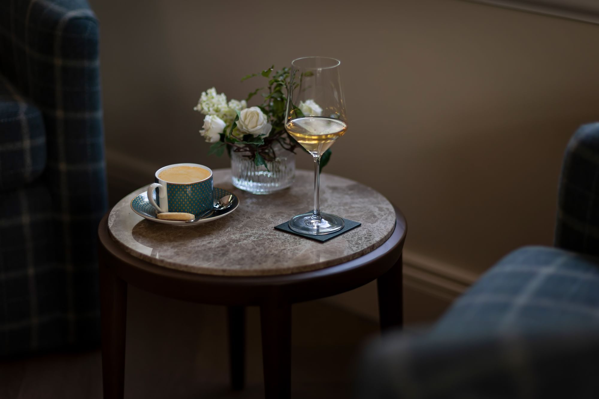 Marble-topped side table with a cup of coffee and a glass of white wine at Dunluce Lodge