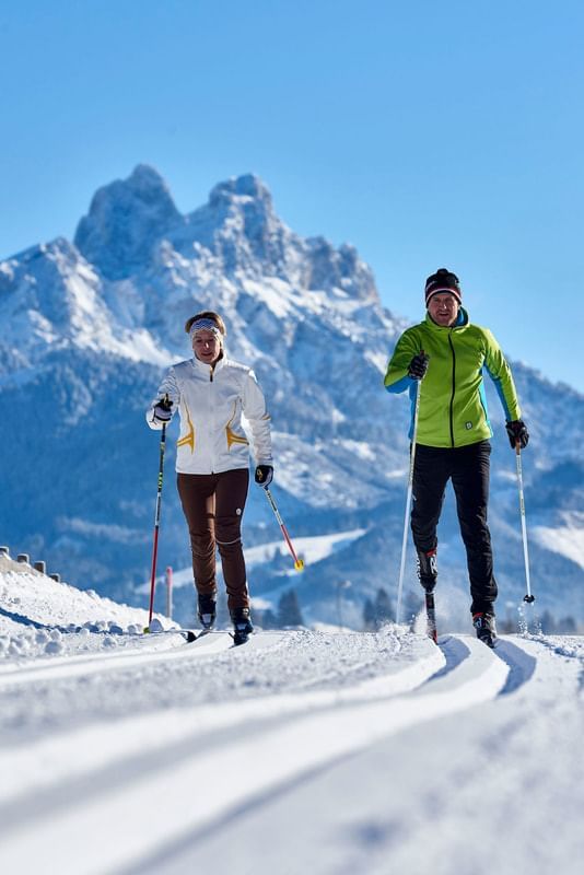 two women skiing with mountain view
