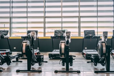 Well-equipped gym with a row of exercise machines at Irazu Hotel