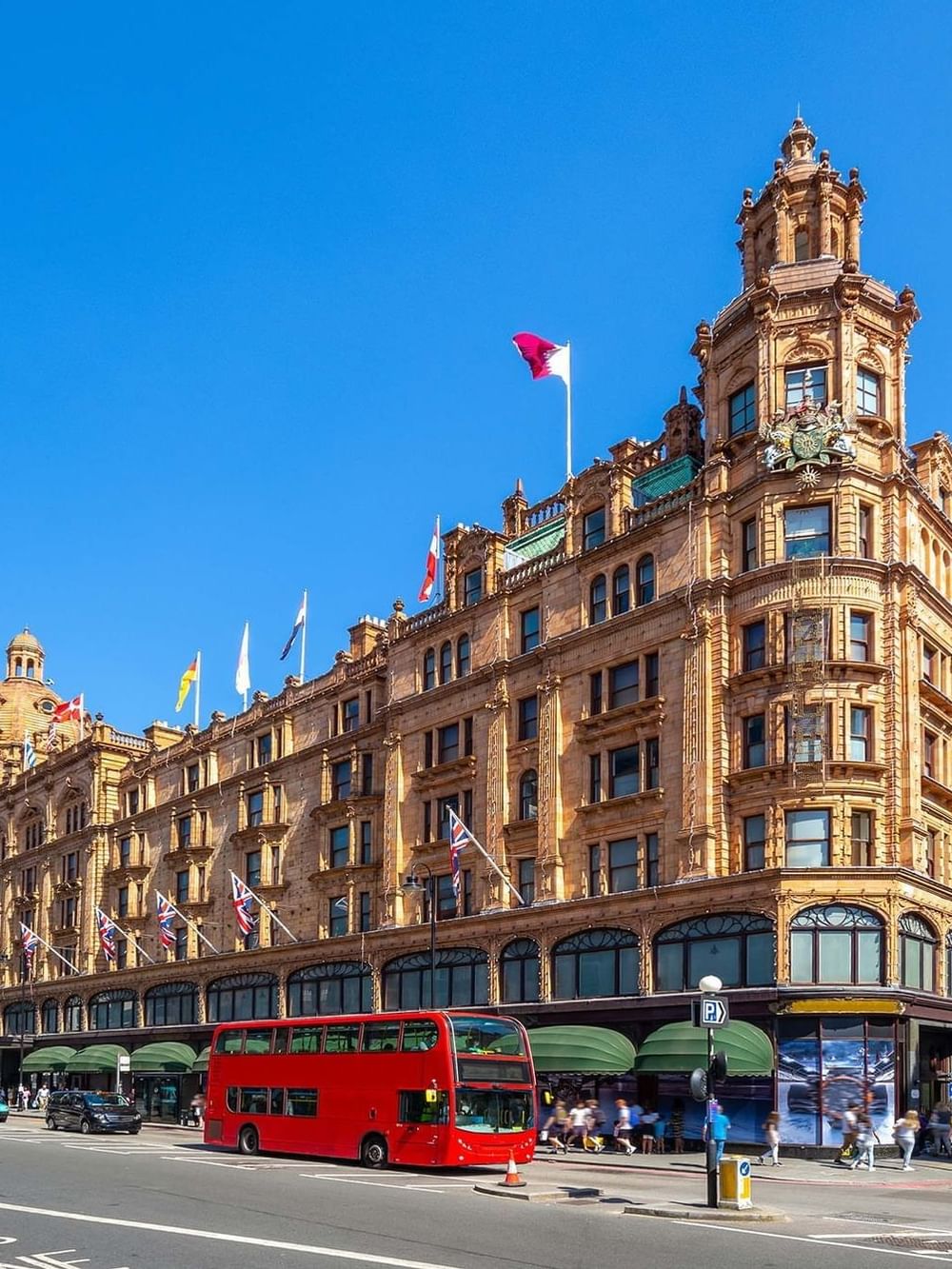 Exterior of the grand department store with red buses driving on the street near Warwick Hotels & Resorts