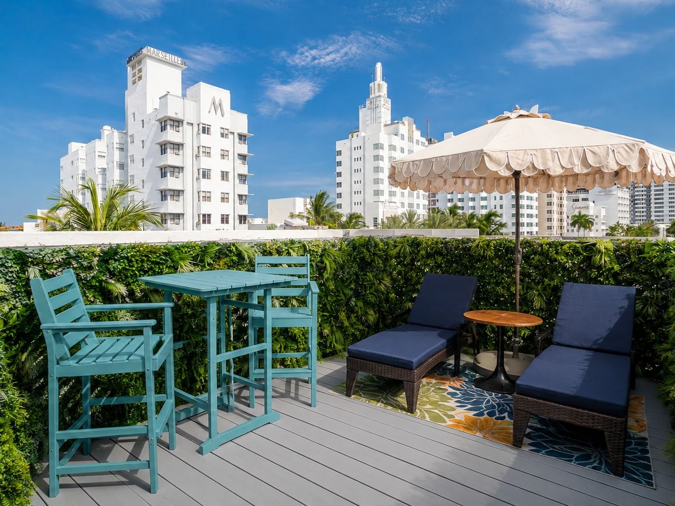 King Bedroom Rooftop Terrace with wicker chairs, colorful pillows, and views of city skyline at Catalina Hotel & Beach Club