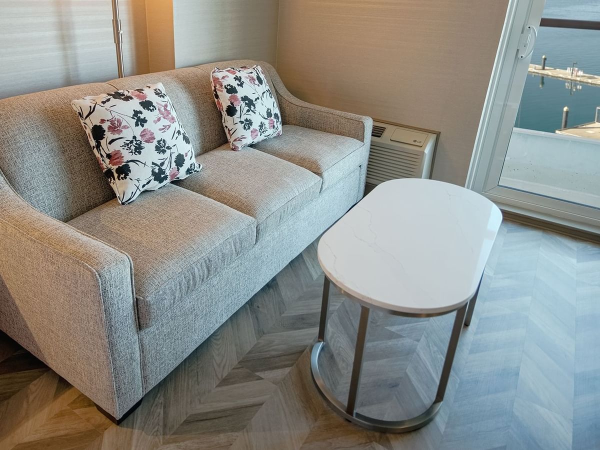 Hotel guestroom with couch, coffee table, and a view of the ocean