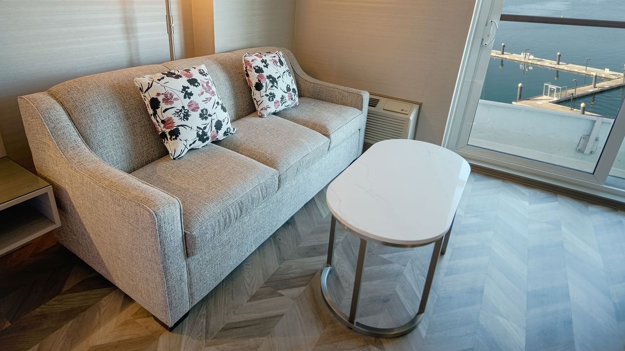 Hotel guestroom with couch, coffee table, and a view of the ocean
