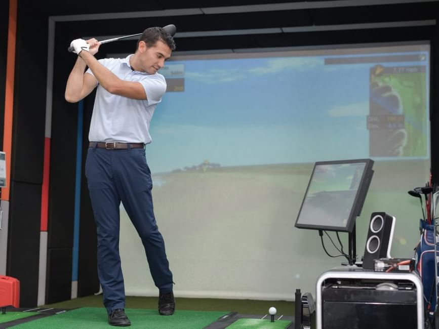 Man playing golf indoors, The Gateway Hotel & Conference Center