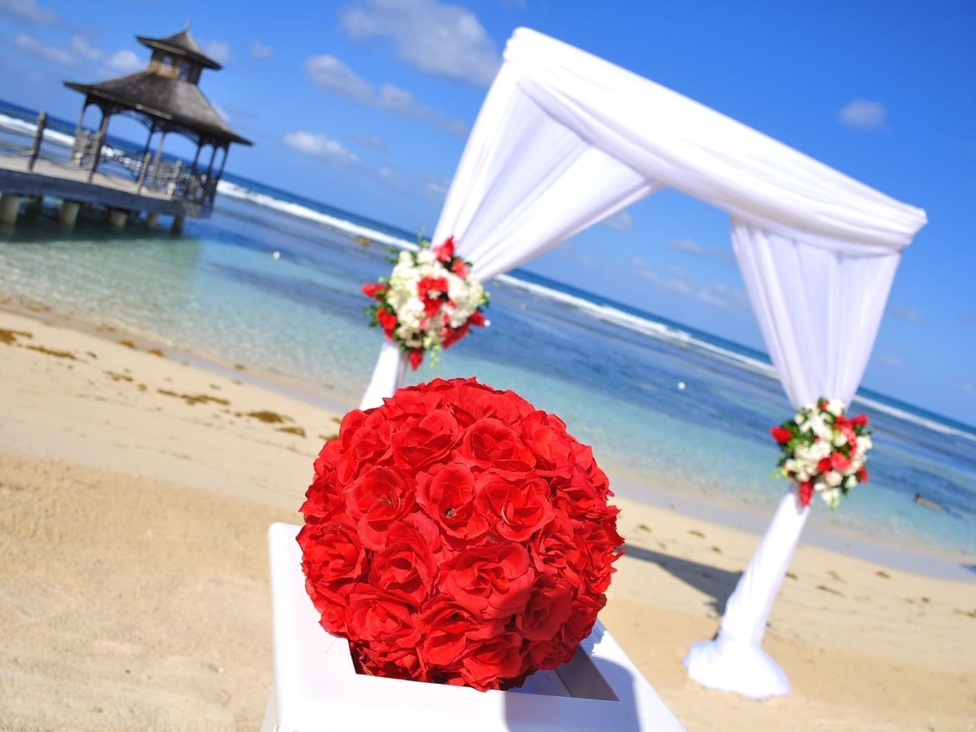 Bouquet of red roses by an arch set-up for a weeding ceremony on a sunny day Holiday Inns Montego Bay