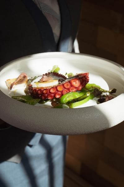 Personne tenant un plat de poulpe et légumes chez Grand Hotel Portovenere