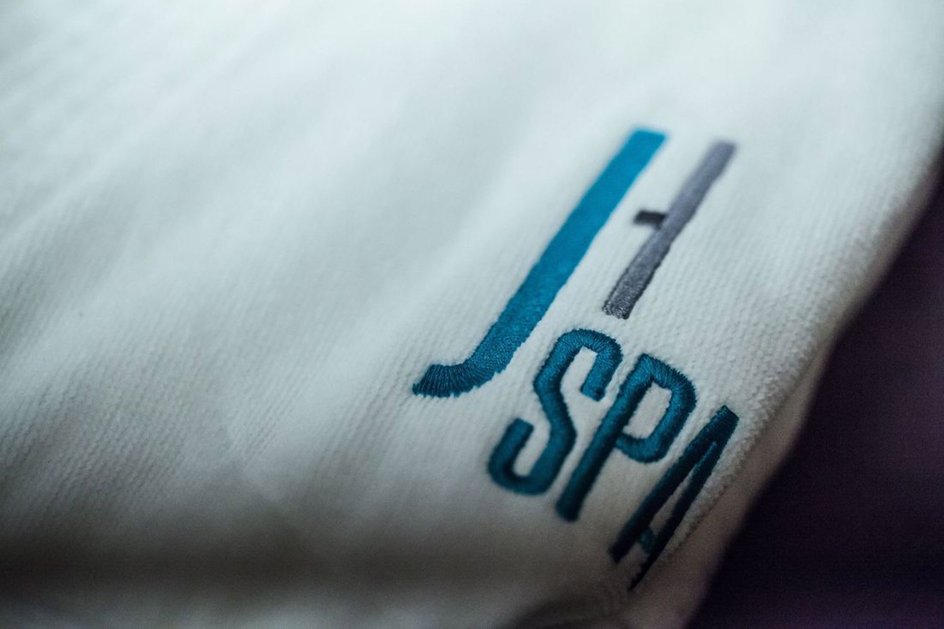 J SPA logo embroidered on a plush white robe in a treatment room at The J House Greenwich