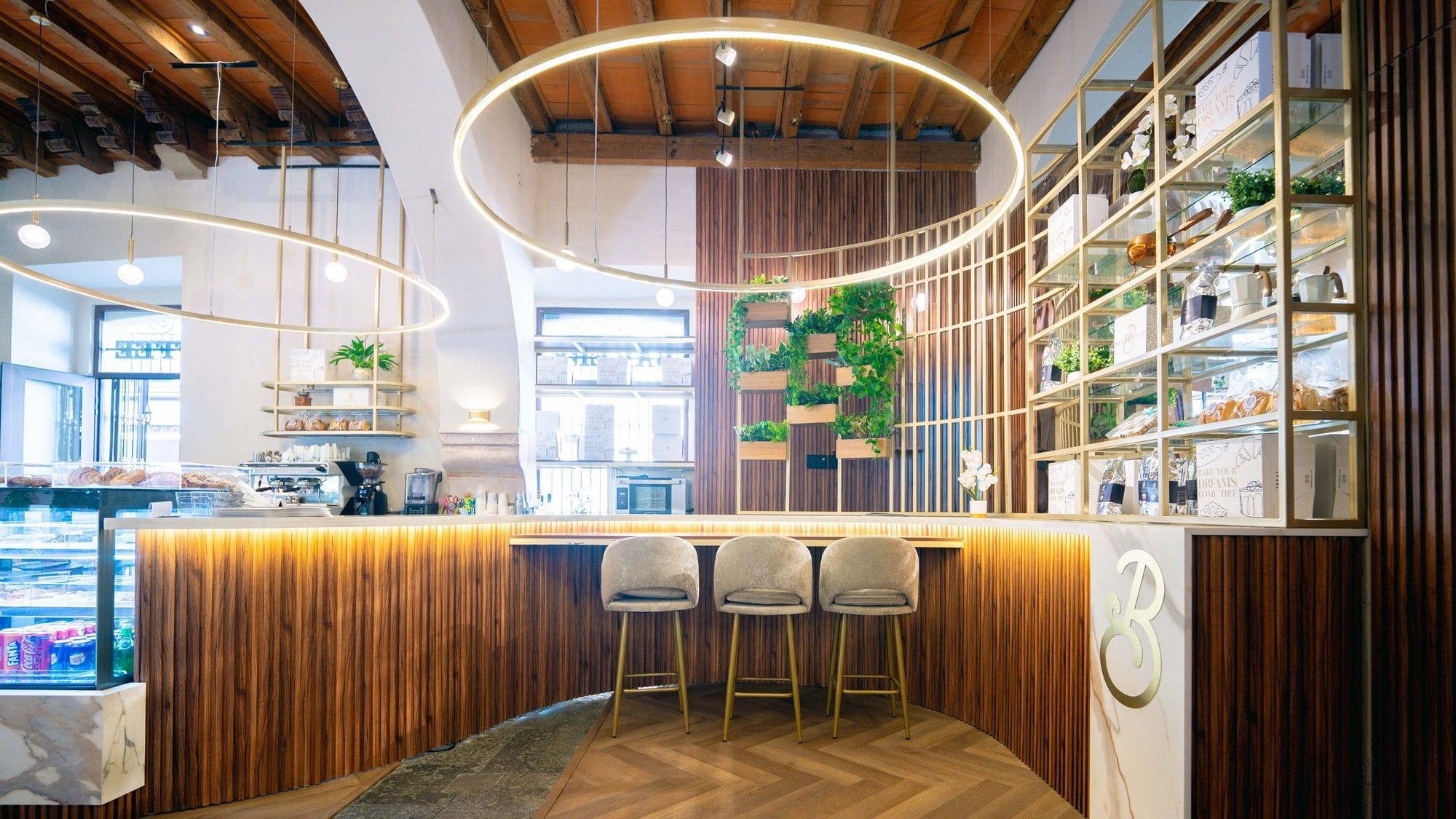 Chic cafe counter with vertical wood paneling and circular halo lighting at Quinta Real Puebla 
