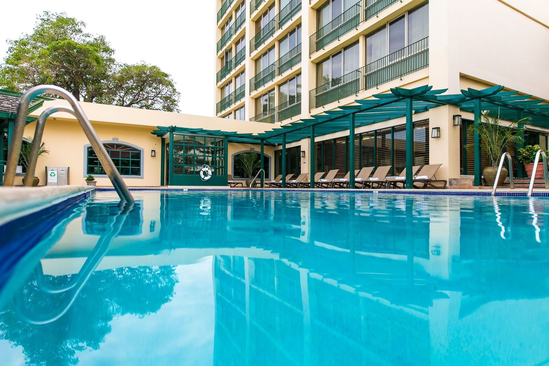 Outdoor pool with lounge chairs at Courtleigh Hotel and Suites