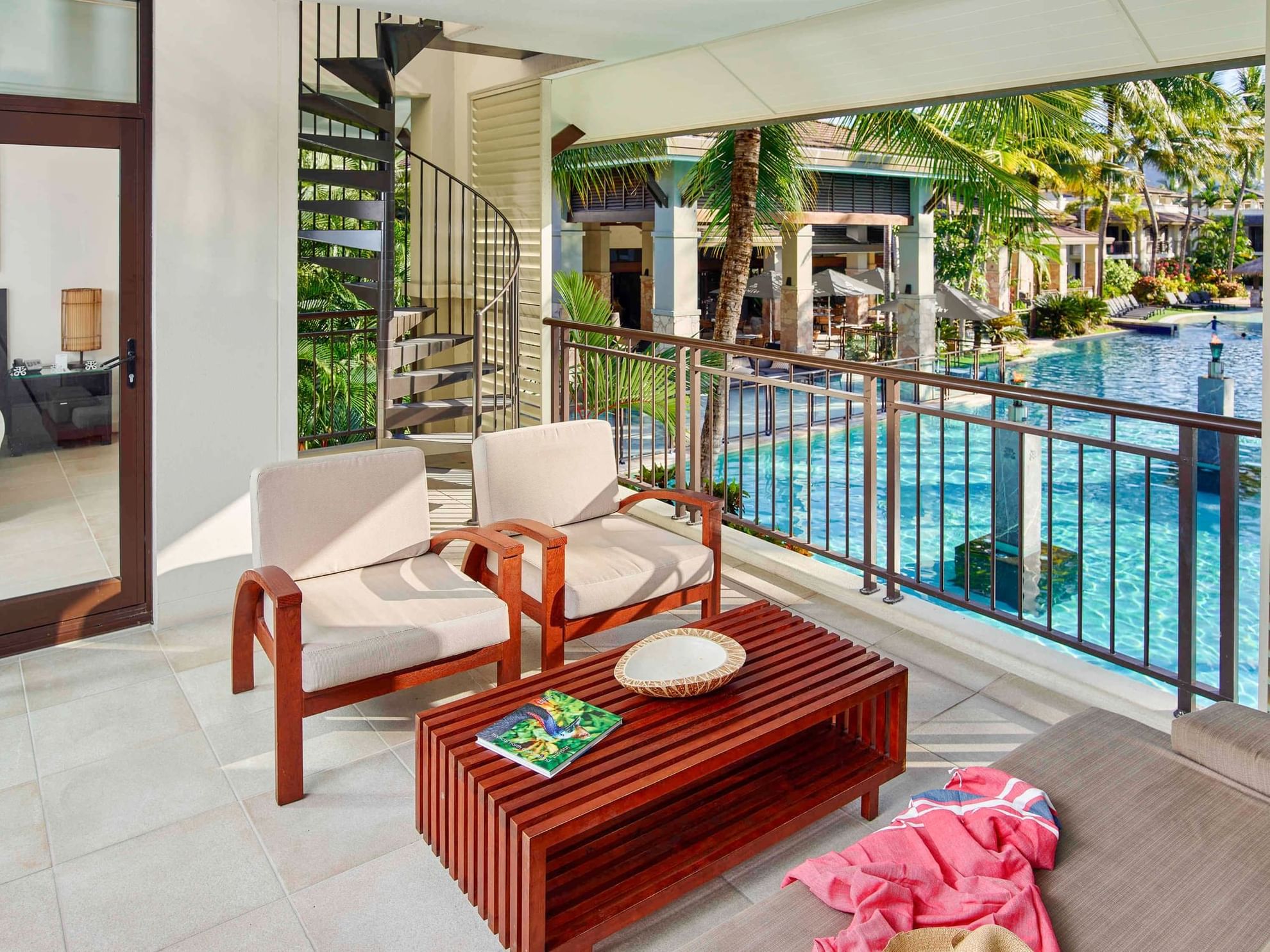 Lounge area with side stair case and outdoor pool view in Penthouse Apartment at Pullman Port Douglas Sea Temple Resort & Spa