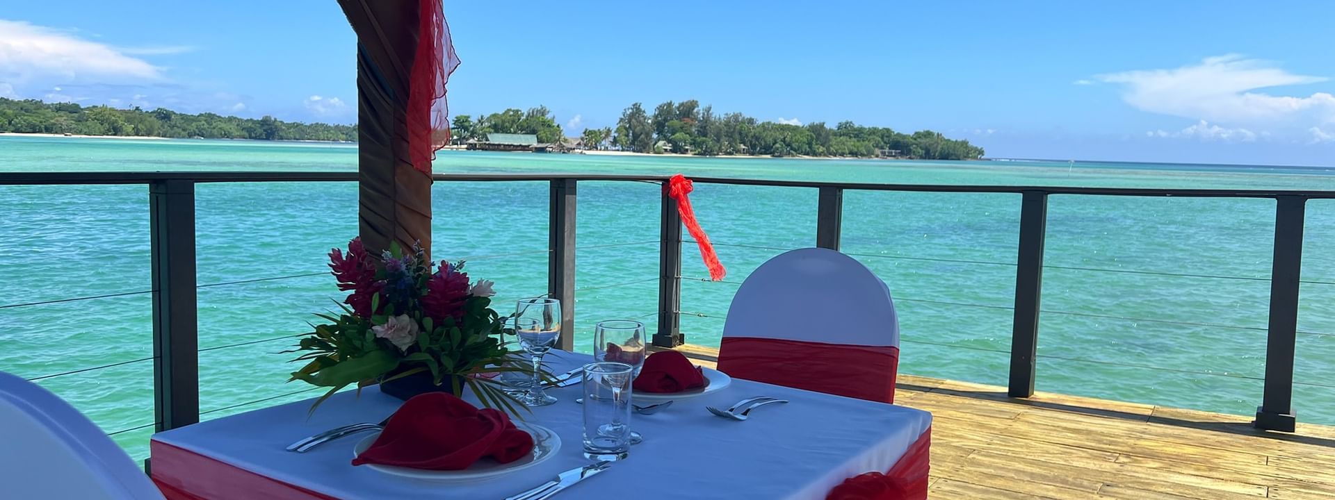 A beautifully set table with ocean view for a Romance and Sunset Cruise at Warwick Le Lagon in Efate