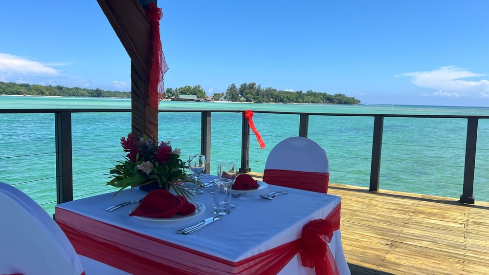 A beautifully set table with ocean view for a Romance and Sunset Cruise at Warwick Le Lagon in Efate.