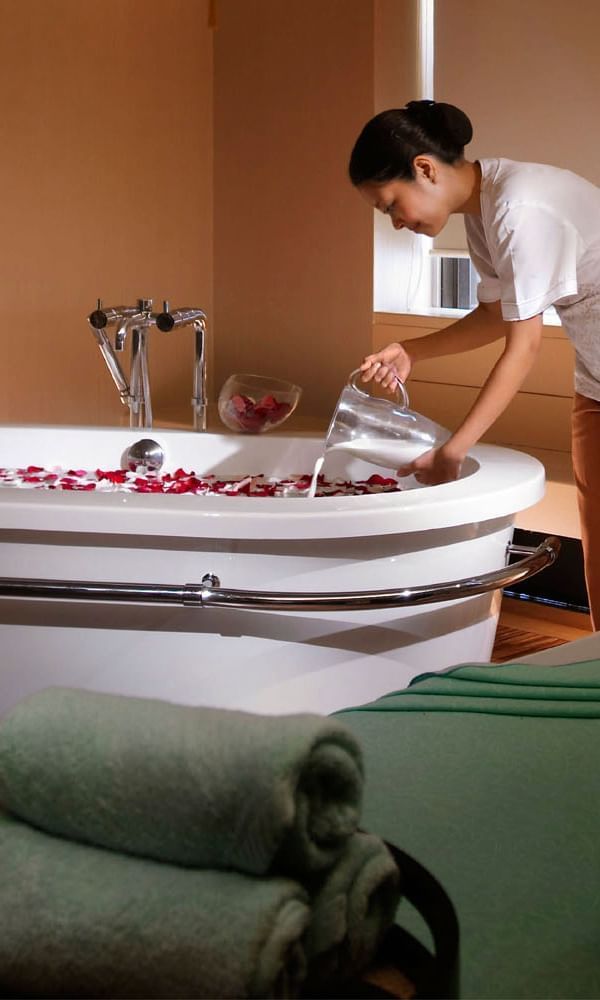 A Lady filling water in the Bath tub at Hotel Maya Kuala Lumpur