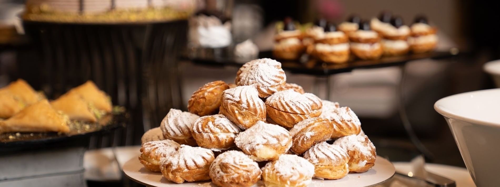 Cream puffs dusted with powdered sugar on dessert buffet in AI Firdous restaurant at Saja Warwick Madinah