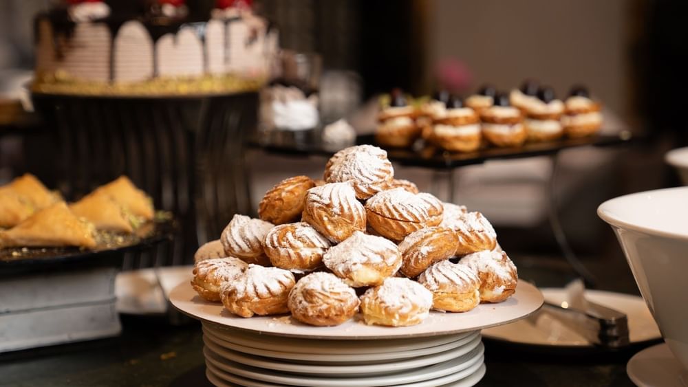 Cream puffs dusted with powdered sugar on dessert buffet in AI Firdous restaurant at Saja Warwick Madinah