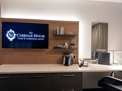 Stylish modern room with flat screen TV and coffee maker at Carriage House Hotel & Conference Centre