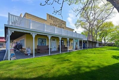 Buffalo Bill Village Gift Shop building with a white railing porch and green lawn