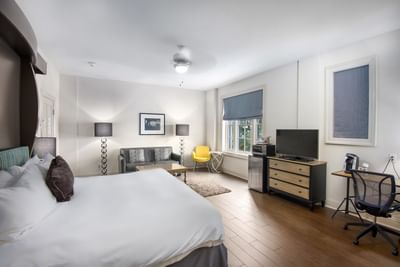 Suite King Bed Residential View, with a large bed, textured rug, and a desk with a chair at The White House Hotel