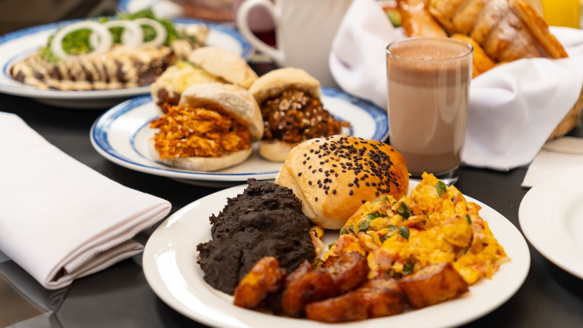 Traditional breakfast with scrambled eggs, black beans, and assorted rolls at Quinta Real in Puebla 