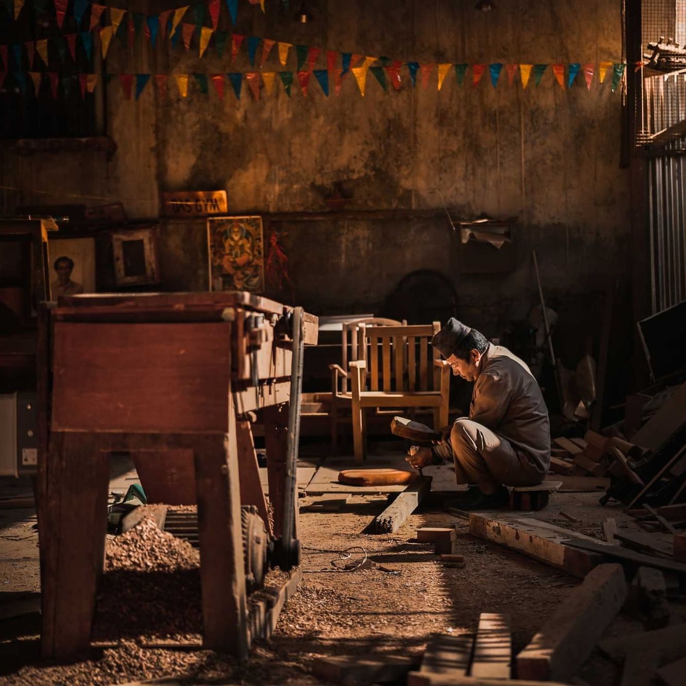 View of a wood worker chipping on wood in a warehouse near The Dwarika’s Hotels and Resorts