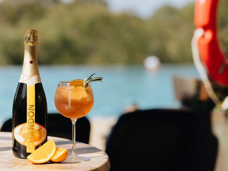 Chandon bottle and orange cocktail by the pool at Pullman Bunker Bay Resort