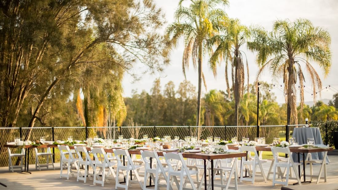 Elegantly set dining tables and chairs under the sunset sky at Mercure Gold Coast Resort in Carrara.