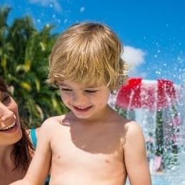 A mother and son play at a splash pad in Aquatica, soon to be home to Turi's Kid Cove.