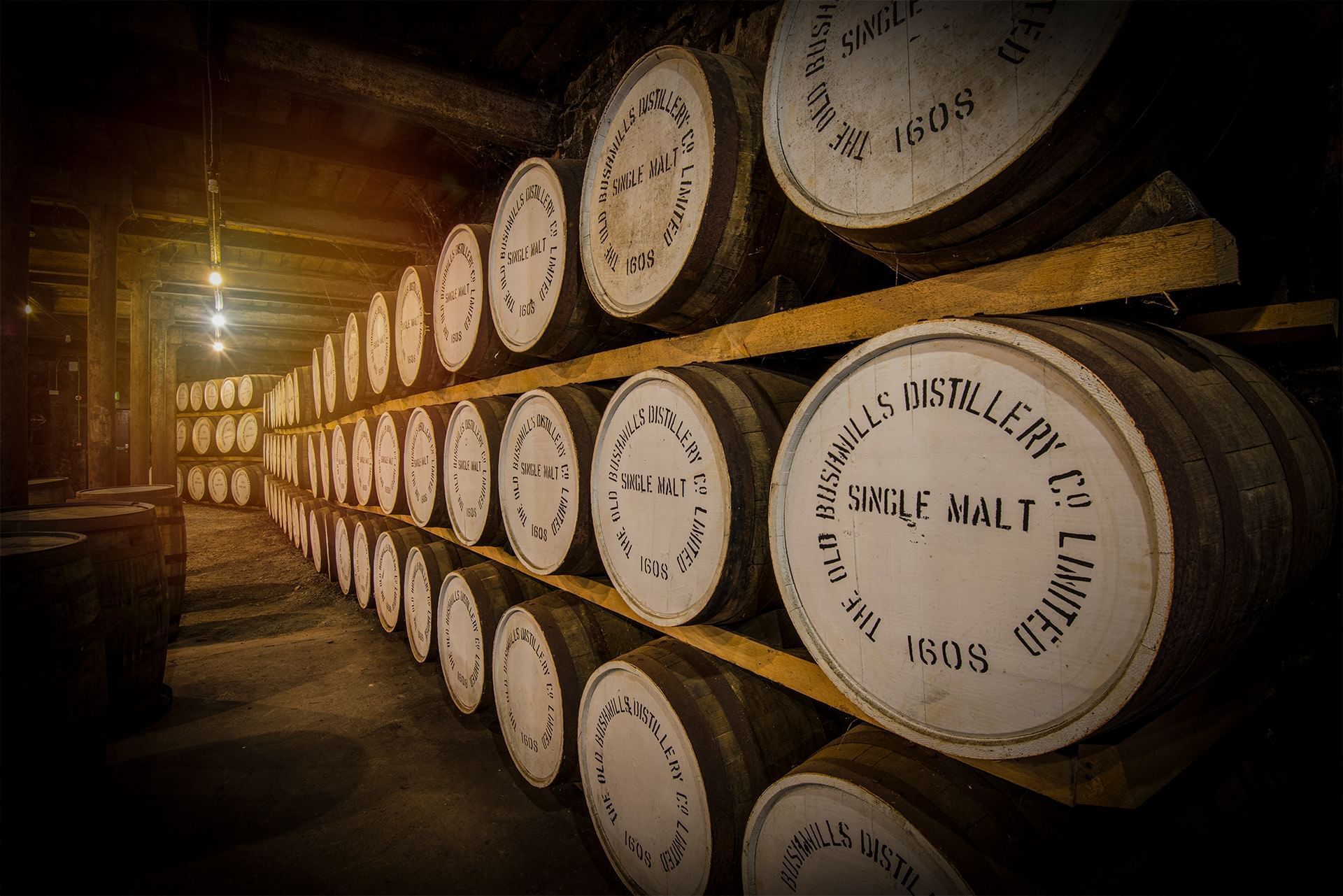 Close-up of stacked whiskey barrels in Old Bushmills Distillery near Dunluce Lodge