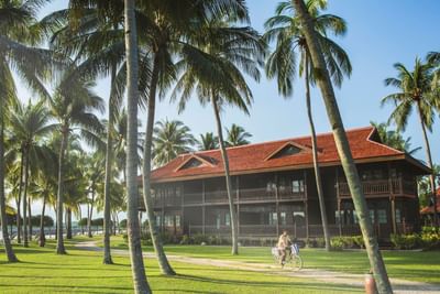 Man riding bike with a hotel view at Pelangi Beach Resort & Spa