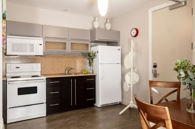 Kitchen area with pantry, dining table & refrigerator in Executive Residences 201 at Retro Suites Hotel