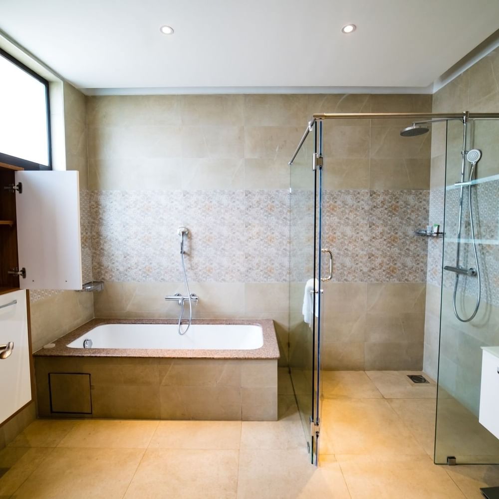 Modern bathroom with bathtub and glass shower enclosure in 4 Bedroom Penthouse at Lake Victoria Serena Golf Resort & Spa, Kampala.