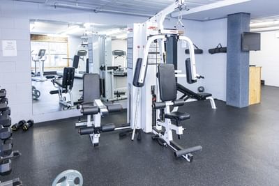 Fitness center with a multi-station weight machine, dumbbells, and wall mirrors at Rodd Grand Yarmouth