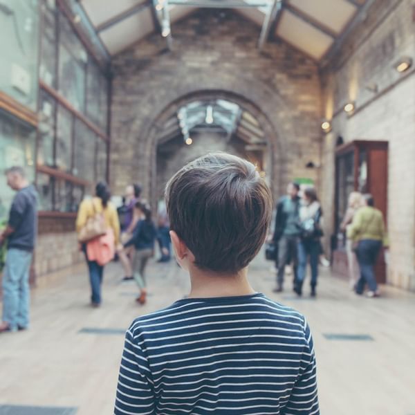 A kid walking in a hallway of a museum at Falkensteiner Hotels