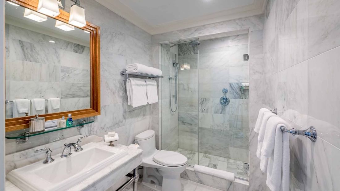 Deluxe King bathroom featuring a walk-in glass shower and modern amenities at El Prado Hotel
