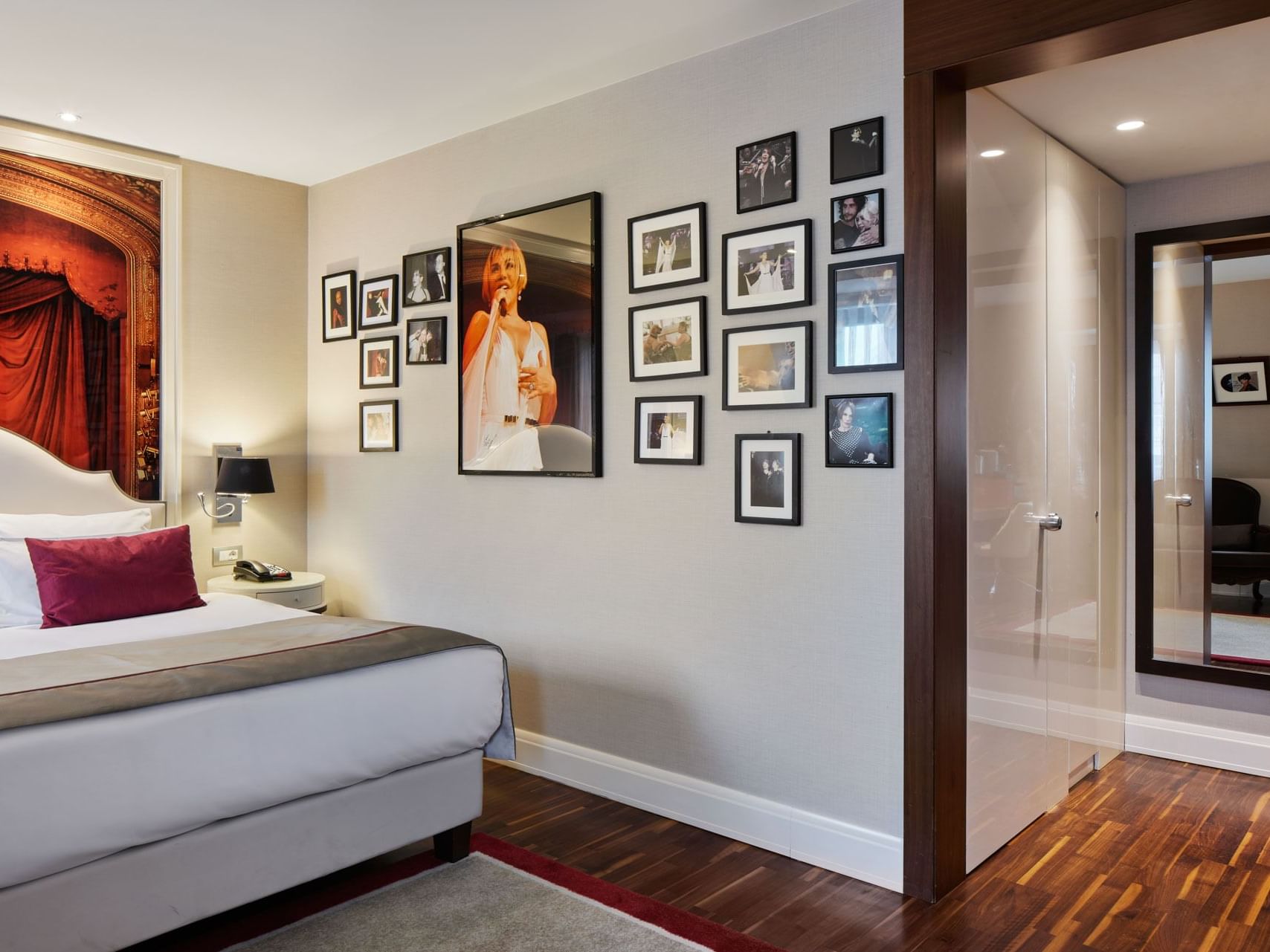 Schlafbereich mit gerahmten Bildern an der Wand in der Sezen Aksu Suite des Titanic Gendarmenmarkt Berlin