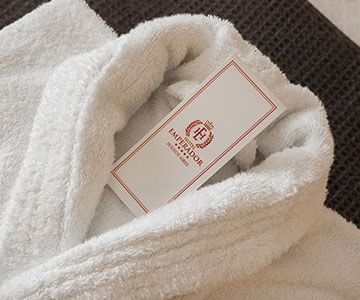 A white bathrobe with the tag of Hotel Emperador Buenos Aires