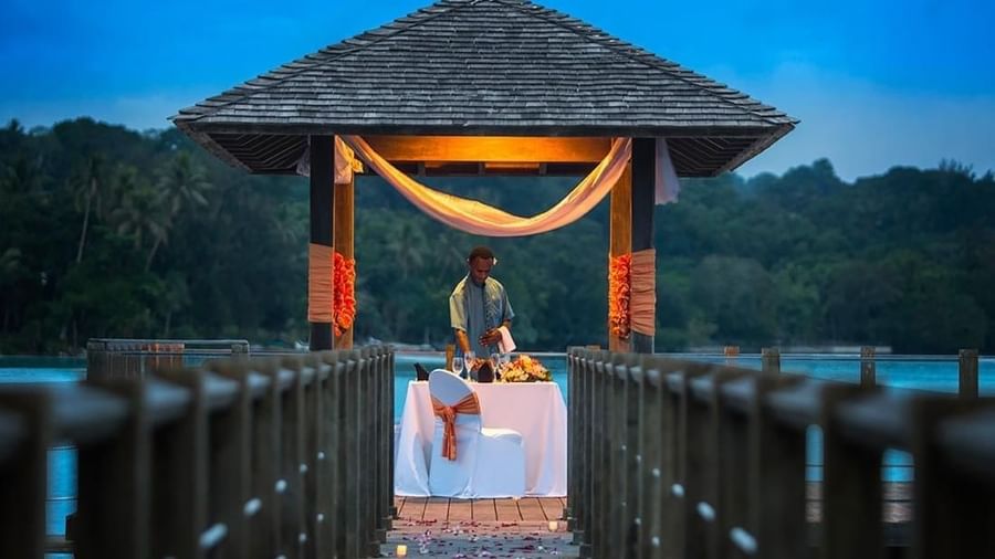 Romantic private dinner set for two under a thatched gazebo on a wooden pier at dusk at warwick le lagon-vanuatu
