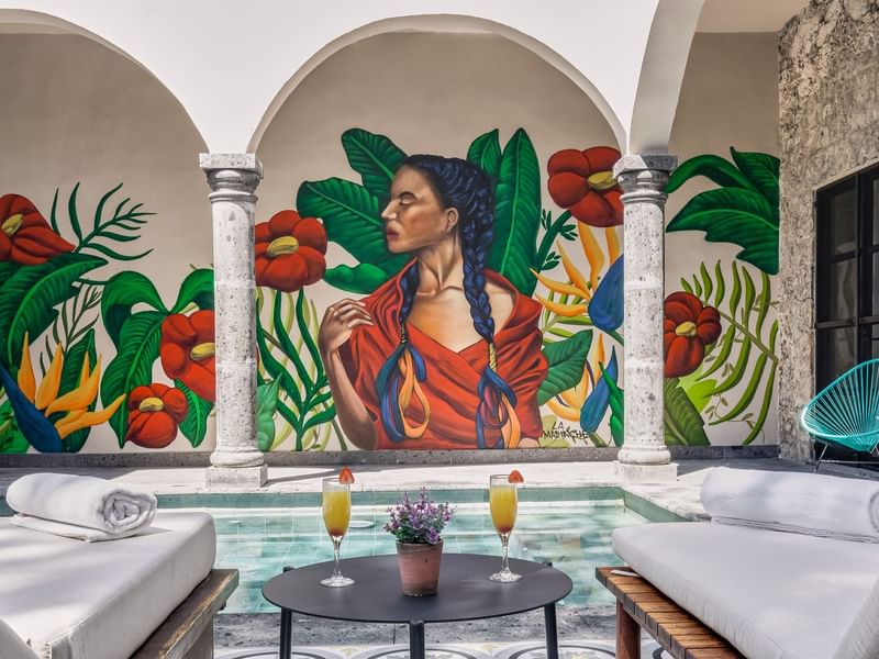 A vibrant mural of a woman adorns the pool wall at Fiesta Americana