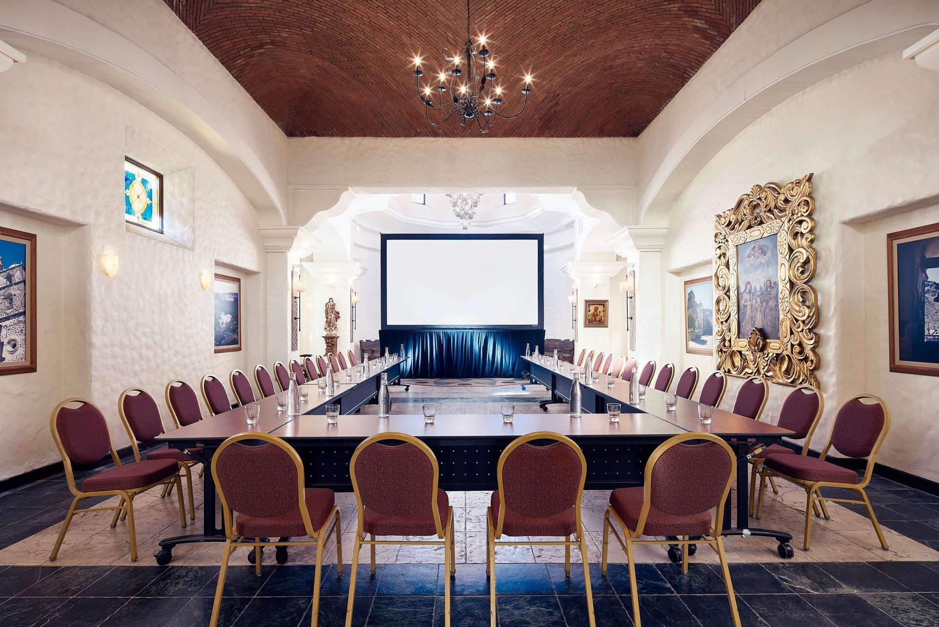 Chapel meeting room with a U-shaped table and chairs under a vaulted ceiling at Hacienda Del Mar Los Cabos
