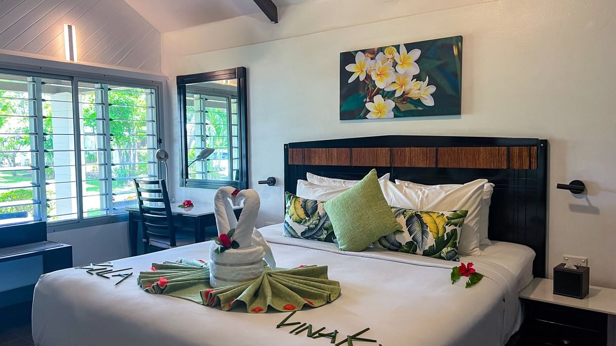 Ornate towel swan display on a master bed featuring plumeria floral art in One Bedroom Villa at TokaToka Resort Nadi Fiji