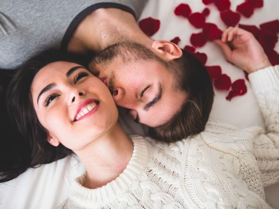 Couple laying in a bed of rose petals
