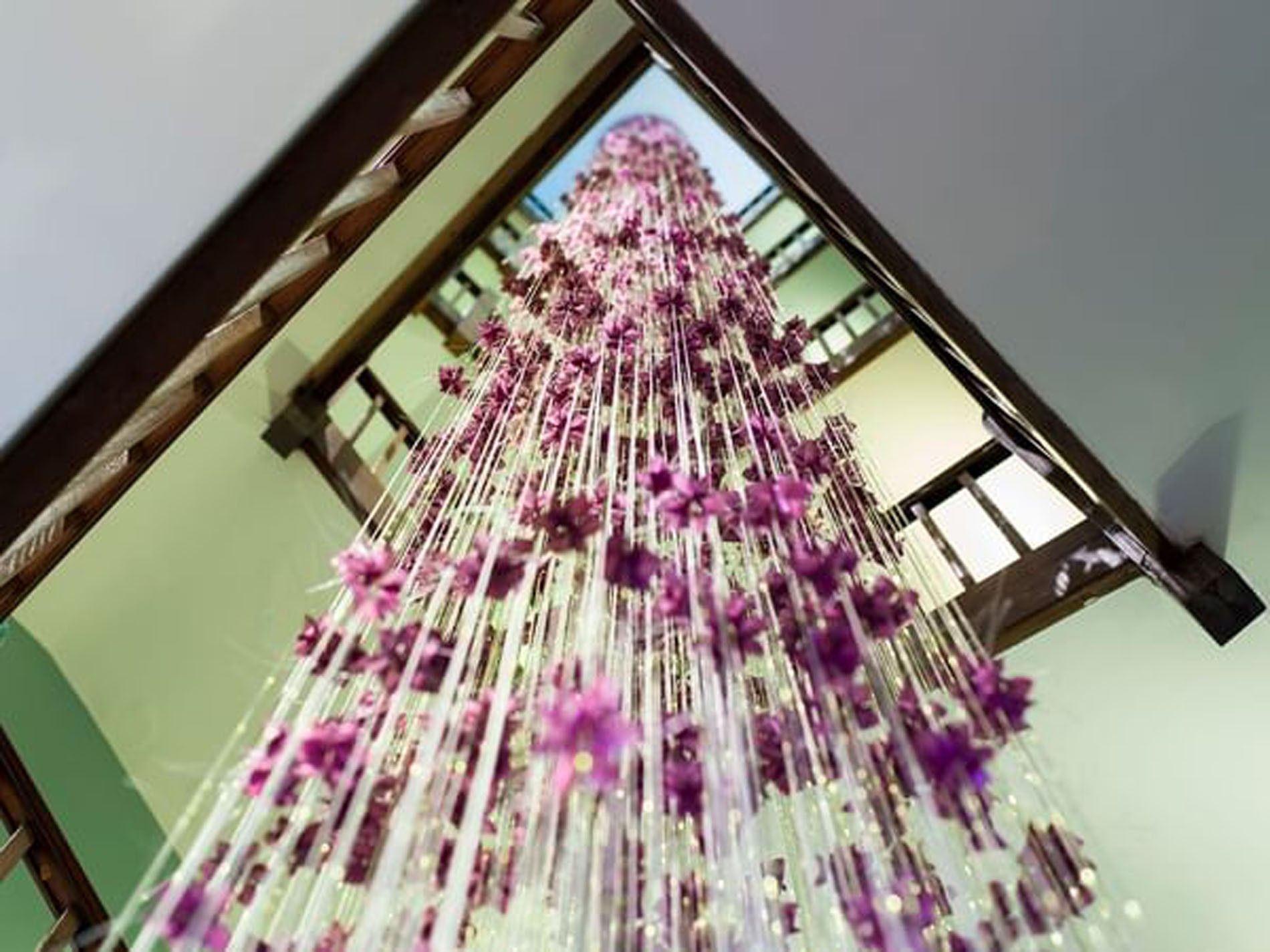Hanging purple floral art installation suspended in the staircase area at The Capital Hotel, Apartments and Townhouse