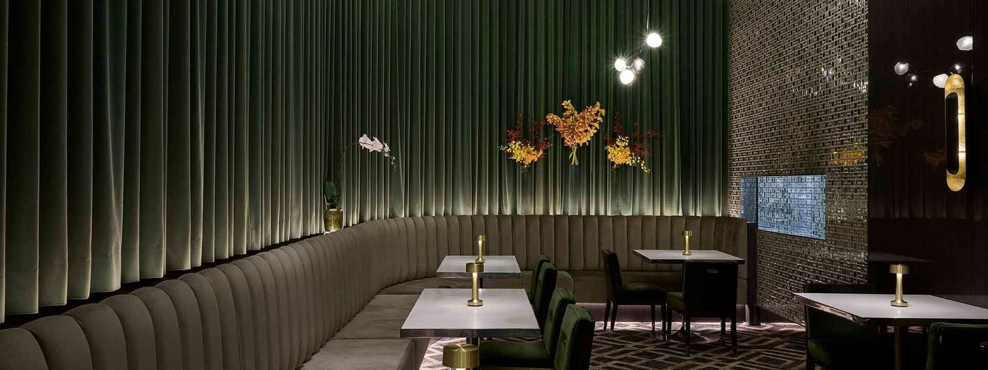 Interior of TWR Bar with green velvet chairs and pleated walls at Crown Hotel Melbourne