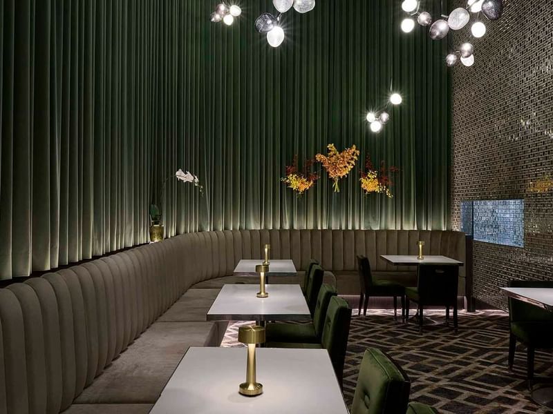 Interior of TWR Bar with green velvet chairs and pleated walls at Crown Hotel Melbourne