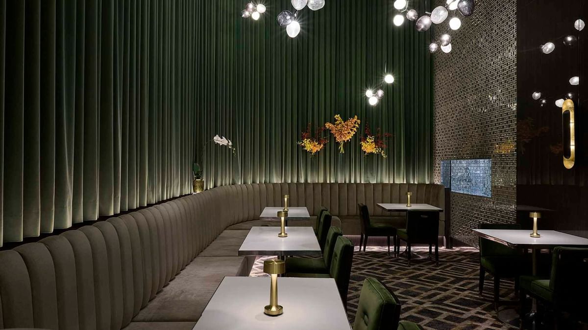 Interior of TWR Bar with green velvet chairs and pleated walls at Crown Hotel Melbourne