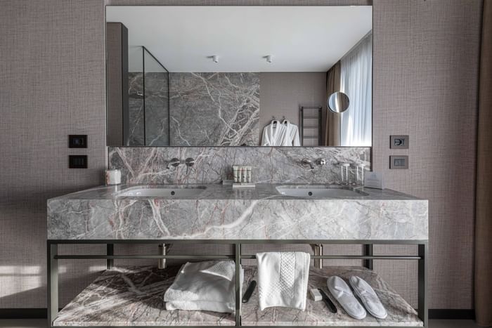 Doppio lavandino in marmo con specchio grande sopra a DUPARC Contemporary Suites