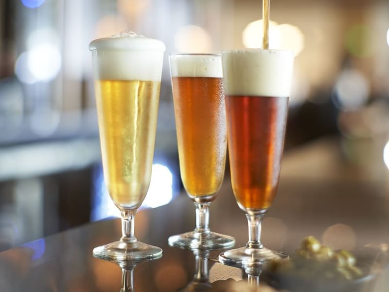 Three glasses of beer served on a counter in Bar Casa Dragones at Live Aqua Resorts and Residence Club