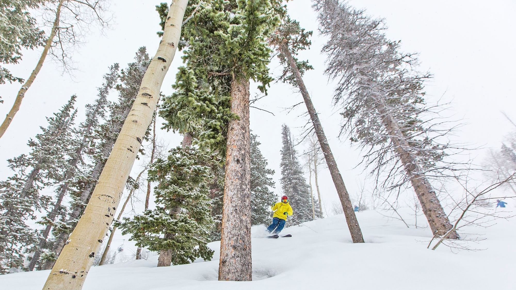 Man skiing on a snow path near Chateaux Deer Valley